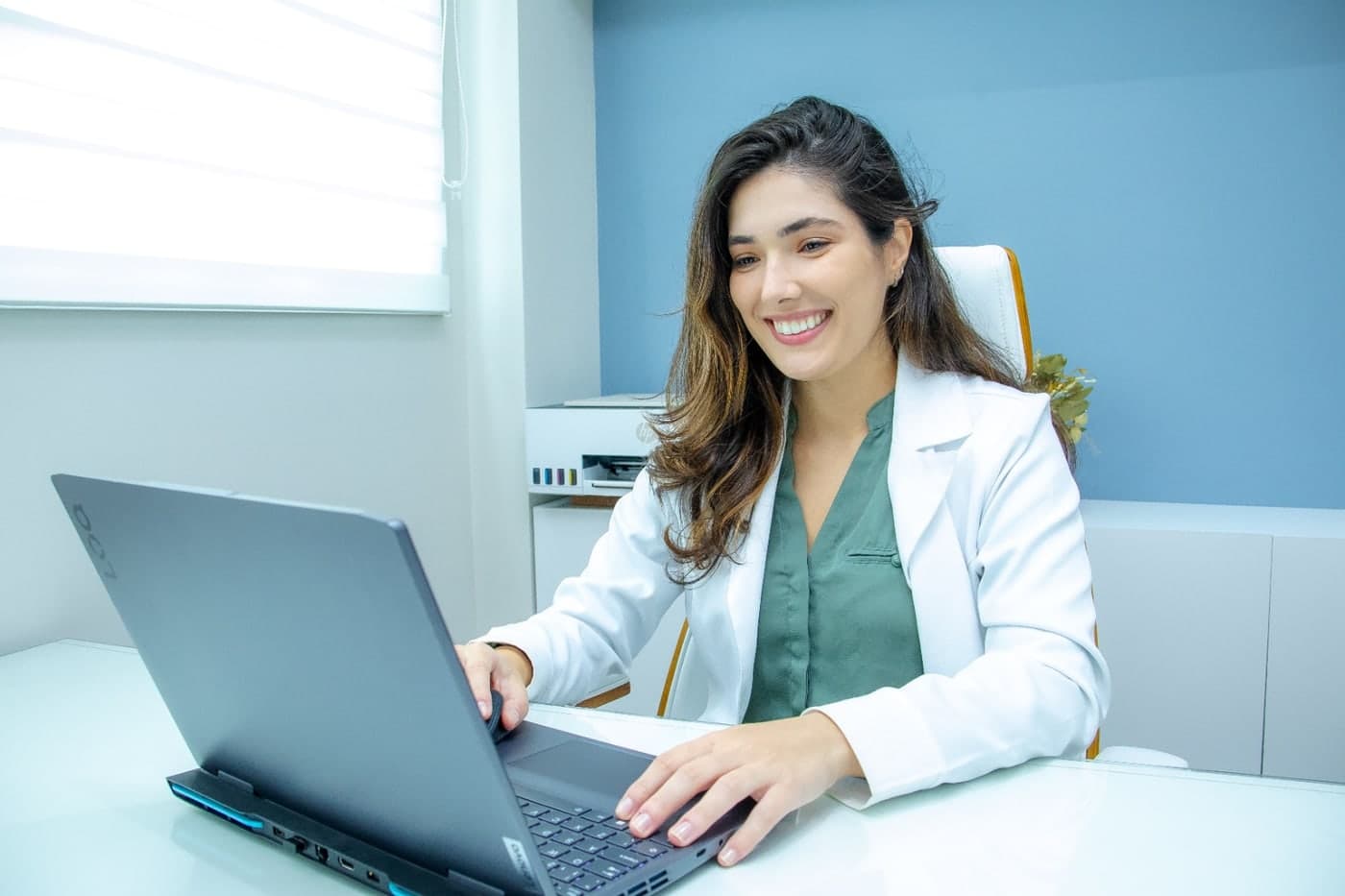 Dra. Fernanda Torraca atendendo um paciente por telemedicina no computador